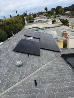 Solar panels on a shingle roof with a view of the neighborhood