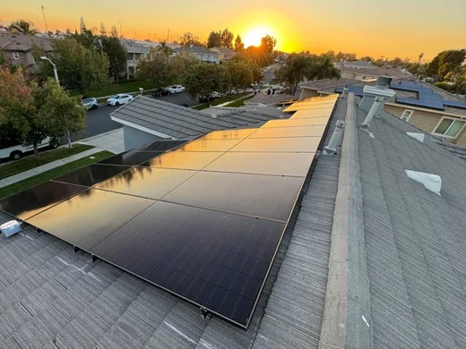 All-black solar array installed by Green Conception on a concrete tile roof at sunset
