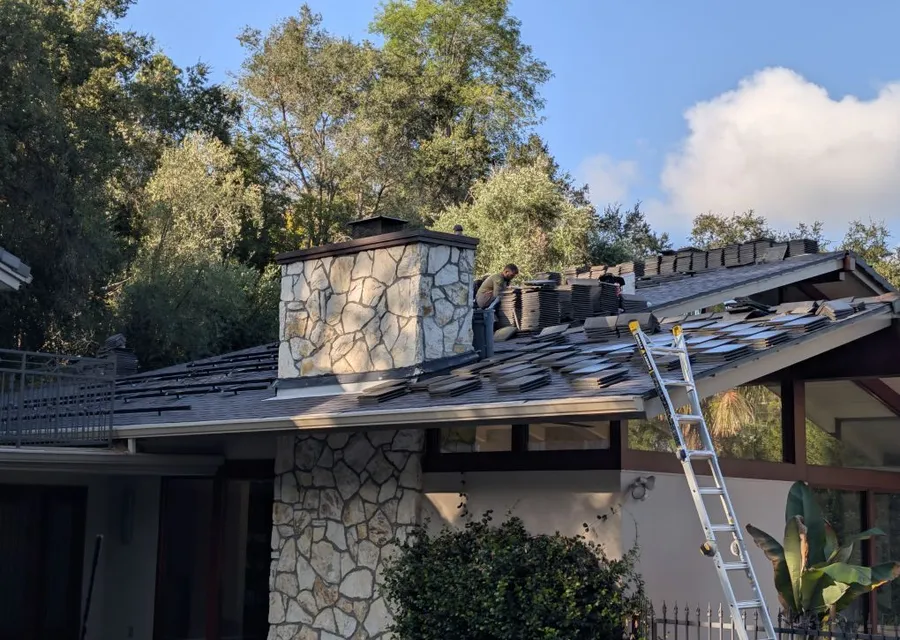 Team removing and stacking concrete roof tiles